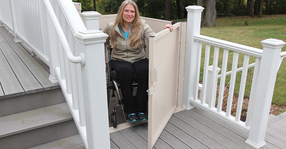 A woman in a wheelchair using an outdoor vertical platform lift
