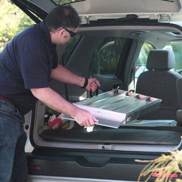 Folding Ramp Man putting folding wheelchair ramp into vehicle
